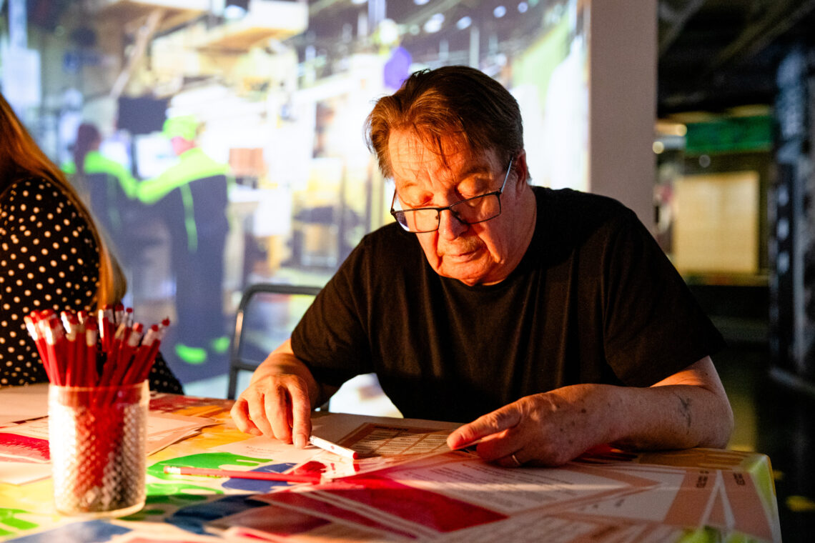 Henkilö syventyy pöydän ääressä tehtävään.