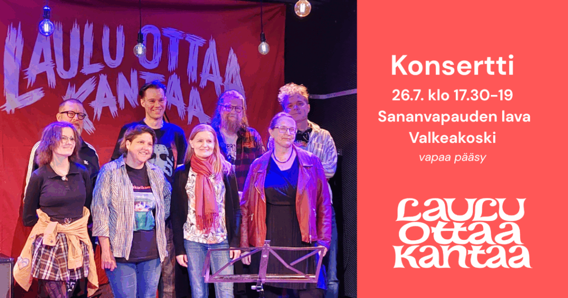 Ryhmä artisteja seisoo lavalla, jonka taustalla on lakana, jossa lukee Laulu ottaa kantaa.